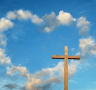 Kreuz vor Himmel mit Wolkenherz.