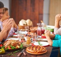 Familie betet vor dem Essen