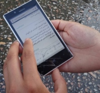 Flchtling mit Smartphone mit arabischer Schrift