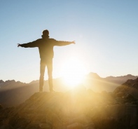 Mann auf Berg bei Sonnenaufgang