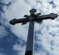 Gipfelkreuz vor bewlktem Himmel