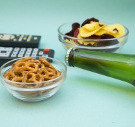 Alkoholflasche, Snacks und Fernbedienung