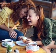 Zwei Freundinnen lachen herzhaft