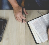 Mann mit Bibel und Smartphone (Symbolbild)