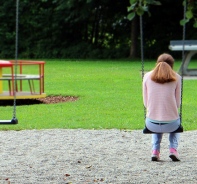 Mdchen alleine auf dem Spielplatz