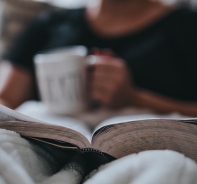 Person liest Bibel im Bett