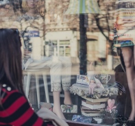 Frau blickt in ein Schaufenster